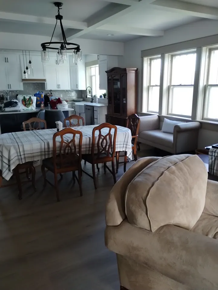 Finished open kitchen and dining room with white cabinets, new floors and coffered ceiling