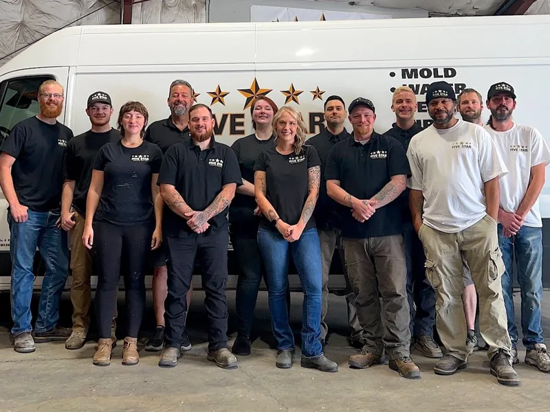 The Five Star Disaster Services team standing in front of a company van